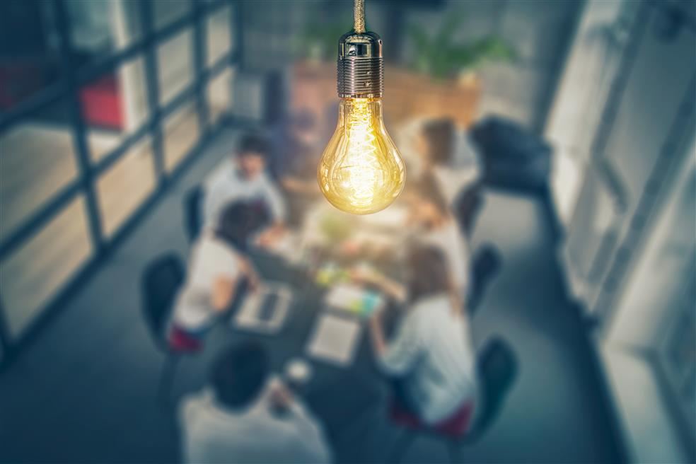 Image of light bulb above a meeting room
